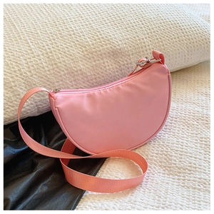 Detail of pink semi-circular nylon kids crossbody bag with metal zipper and wide strap