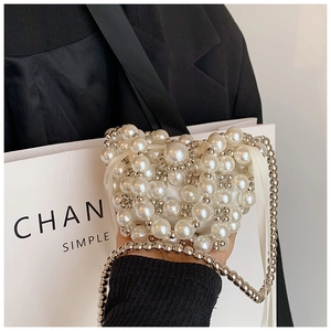 Detail of heart-shaped pearl woven handbag with satin drawstring lining and elegant chain