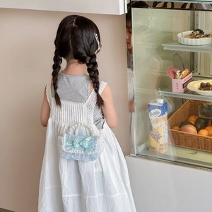 Kids light blue crossbody bag with bow, pearl handle, and lace trim shown on a child
