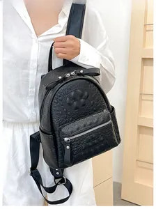 Detail of minimalist black backpack with faux crocodile texture and side pocket