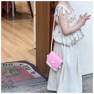 Détail d'un sac à bandoulière en silicone rose pour enfant avec bords ondulés