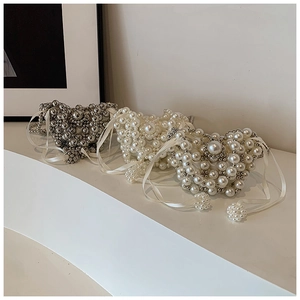 Detailed view of heart-shaped pearl and silver beaded mini bags with satin drawstrings
