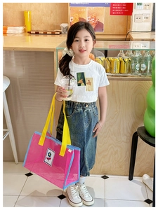 Détail d'un sac en filet rose pour enfants avec anses jaunes et motif floral d'été