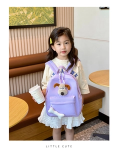 Close-up of purple school bag with cute Gromit plush character and bone pendant detail