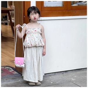 Tenue d'été à pois colorés avec un sac bandoulière rose à bords ondulés en extérieur