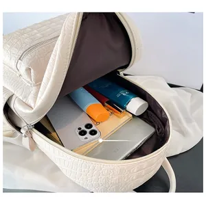 Detail shot of white crocodile pattern backpack with spacious interior and brown lining