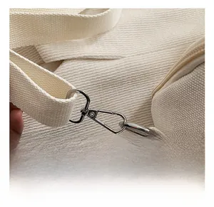 Detail of high-quality silver metal hook and thick white canvas strap on the diaper bag