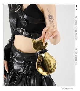 Macro shot of metallic gold cat-shaped mini bag with glossy mirror finish and black strap