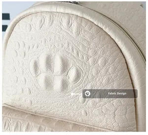 Detail shot of white crocodile embossed PU leather fabric with metallic zipper on backpack