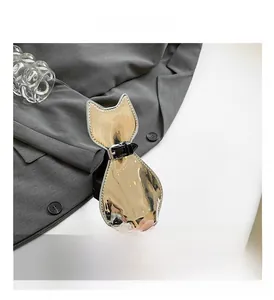 Macro shot of polished gold cat-shaped bag accessory with sleek metal finish