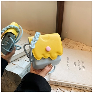 Détail du sac bandoulière enfant tricolore avec rabat ondulé et bandoulière tressée bleue