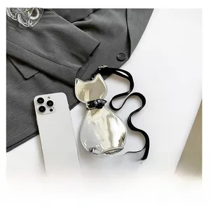 Mini silver cat-shaped crossbody bag shown next to a smartphone for size comparison