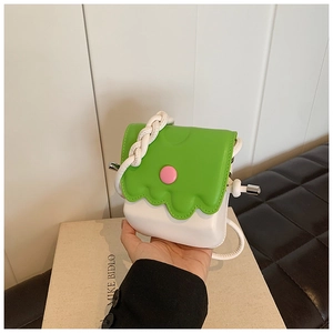 Détail du mini sac bandoulière avec rabat vert ondulé et bouton décoratif rose