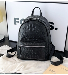 Detail of black faux crocodile embossed backpack with unique claw mark pattern