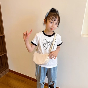 Simple beige semi-circle crossbody bag for kids with adjustable fabric strap shown on model