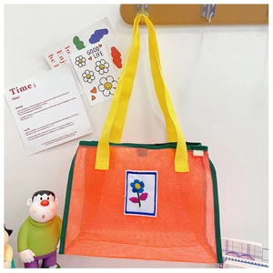 Détail du sac en filet pour enfants orange et jaune avec broderie de fleurs