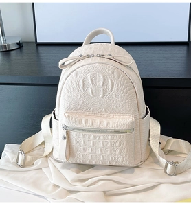 Close-up of white minimalist backpack featuring premium crocodile texture and zipper details
