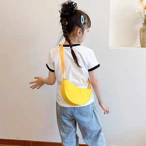 Minimalist yellow semi-circle crossbody bag for children shown on kid model back view