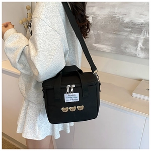 Detail of black multipurpose diaper bag with cute bear embroidery and double zippers