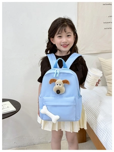 Detail view of light blue toddler backpack featuring a 3D plush dog head and bone charm