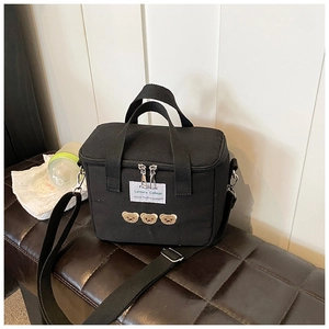 Detail of black canvas diaper bag with cute bear embroidery and adjustable shoulder strap