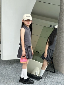 Détail de l'ensemble gris pour fille avec haut polo sans manches et jupe plissée