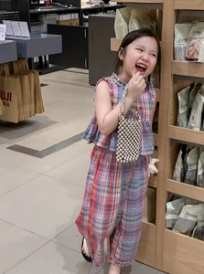 Close-up of a child model holding a silver metallic woven beaded bucket handbag