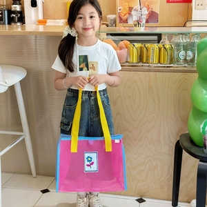 Sac cabas enfant en maille rose avec sangles jaunes et écusson fleuri pour la plage d'été