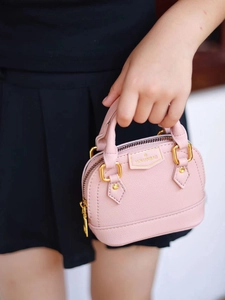 Détail du mini sac à main rose en forme de coquille avec des finitions dorées