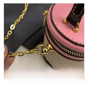 Nahaufnahme des goldenen Metallhakens und der rosa Ledernähte an der Mini-Tasche