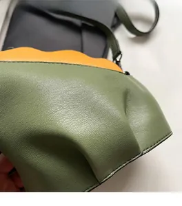 Détail de bord ondulé sur sac bandoulière en cuir grainé litchi vert et jaune vif