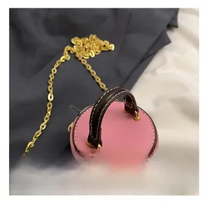 Detailansicht der Mini-Rundtasche für Kinder mit rosa Leder und goldener Kette