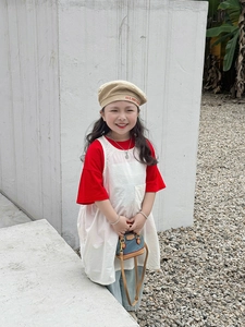 Photo en extérieur d'un ensemble mode enfant avec t-shirt rouge et mini sac coquille