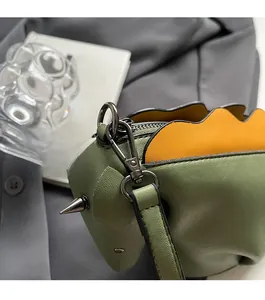 Détail du sac en cuir PU vert avec bordure orange et ferrures en métal noir poli