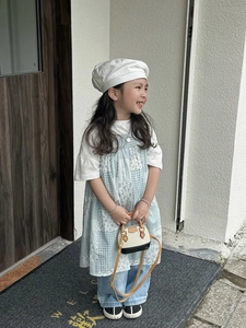 Mini sac coquille pour enfant avec béret blanc et tenue florale dans un décor extérieur