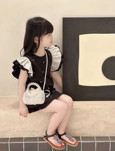 Detail of a white woven pearl pillow bag with round handle and gold chain for kids