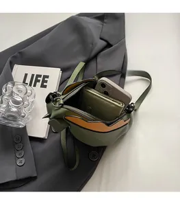 Détail du sac bandoulière cheval vert et camel montrant l'espace de rangement intérieur