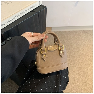 Détail du mini sac en cuir kaki avec logo doré et fermeture éclair sur le côté