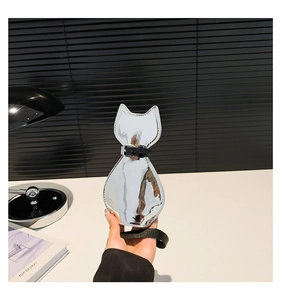 Detail of silver mirror cat-shaped crossbody bag with black leather strap and nylon cord