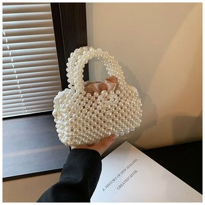 Detail of hand-woven pearl handbag featuring a silk satin drawstring pouch and pearly handle