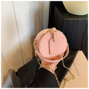 Détails du mini sac rond rose pastel avec sa chaîne dorée et sa fermeture à glissière