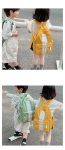Outdoor shot of children wearing large capacity color block school backpacks with white stripes