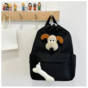 Detail of black canvas backpack featuring plush cartoon dog head and white bone charm accessory