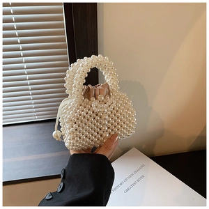 Detail view of handmade pearl woven handbag with a champagne satin drawstring lining
