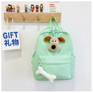 Close-up of a mint green kids backpack with cute plush dog and bone accessories