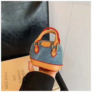 Détail du mini sac en denim avec garniture en cuir orange et boucle en métal en forme de D