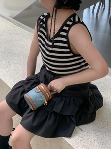 Außenaufnahme eines Kindes mit einer blauen Mini-Zylindertasche aus Denim mit Lederbesatz