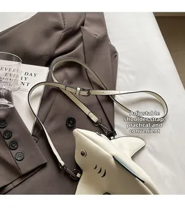 Détail du sac bandoulière en forme de requin avec sangle réglable sur fond lifestyle