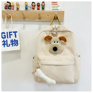 Close-up of off-white nylon kids backpack with plush dog design and bone charm detail