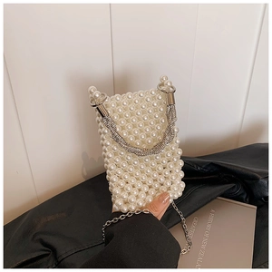 Close-up of white pearl beaded mini bucket bag with rhinestone handle and silver chain